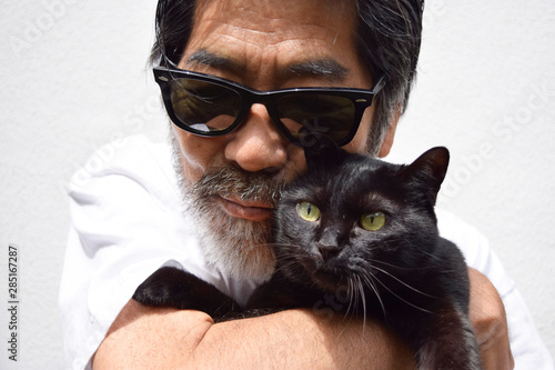 飼い猫を抱っこしている60代の男性 photo