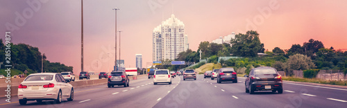Night traffic. Cars on highway road at sunset evening in typical busy american city. Beautiful amazing urban view with red, yellow sky. Sundown in downtown. Web header banner for website.