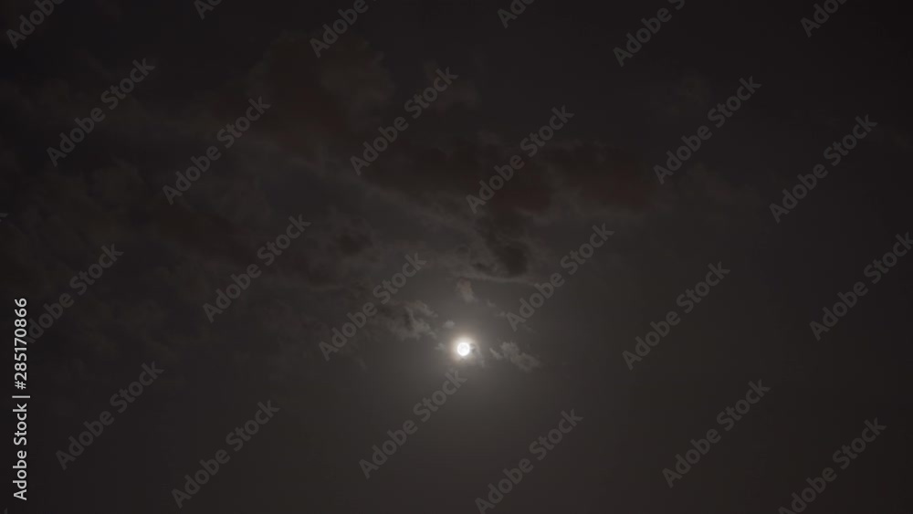 Moon shining behind clouds at night. Wide shot timelapse Moon shining behind clouds at night. Wide shot timelapse