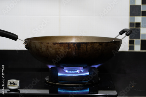 Gas stove burner with blue flames and dark background.