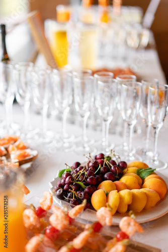Fresh Fruit platter buffet at business or wedding event venue. Self service or all you can eat - cherries, nectarine, grapes and pineapple. Table with cold drink and snacks and tableware
