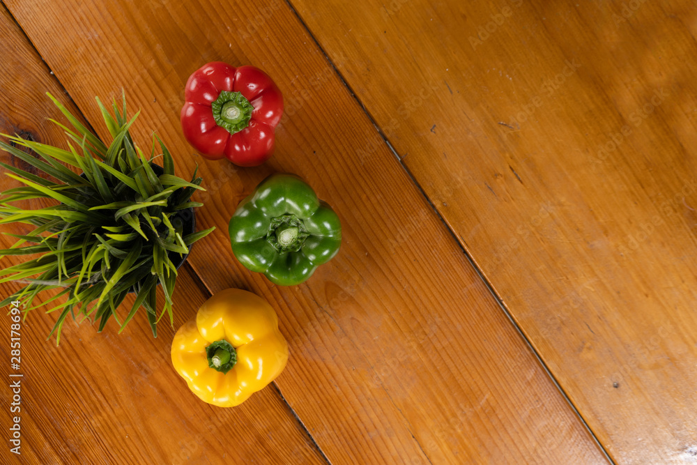 capsicum flat-lay at brown wooden background