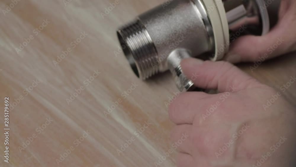 Plumber working on waste unit for bathroom faucet Plumber working on waste unit for bathroom faucet
