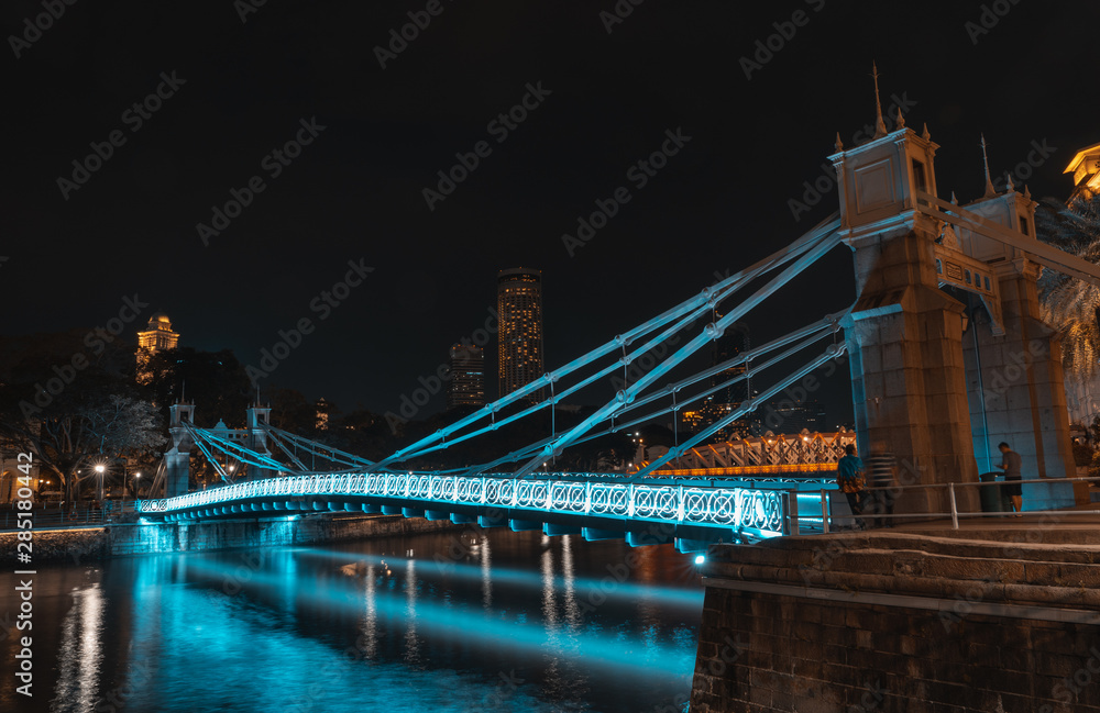 Fototapeta premium SINGAPORE - MAY 19, 2019: Cavenagh Bridge one of the oldest bridges in Singapore, that spans across the Singapore River in the Downtown by night.