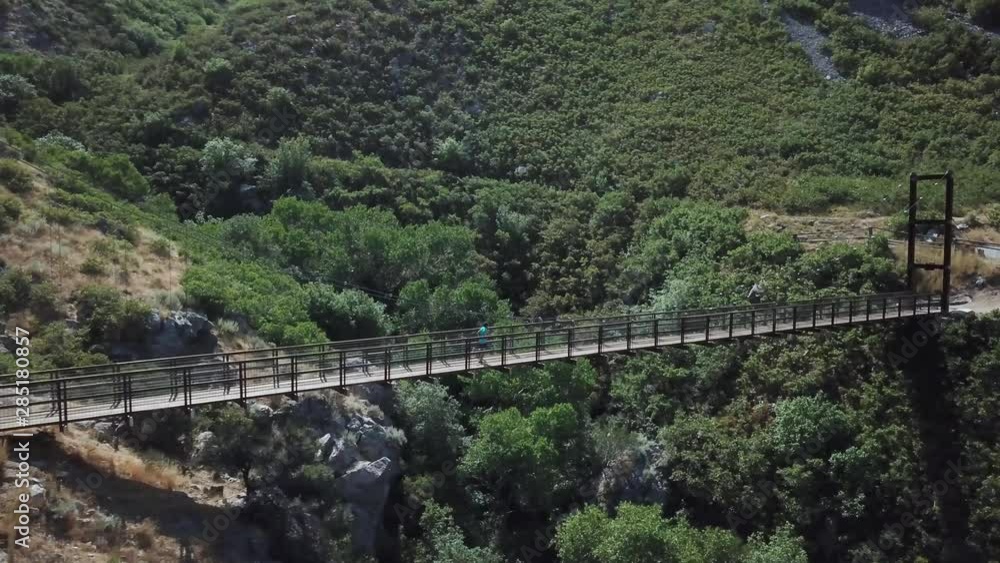 Drone Shot following an active man running on an outdoor hanging