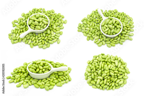 Multiple sets of green fresh soybeans and ceramic bowls placed on white close-up
