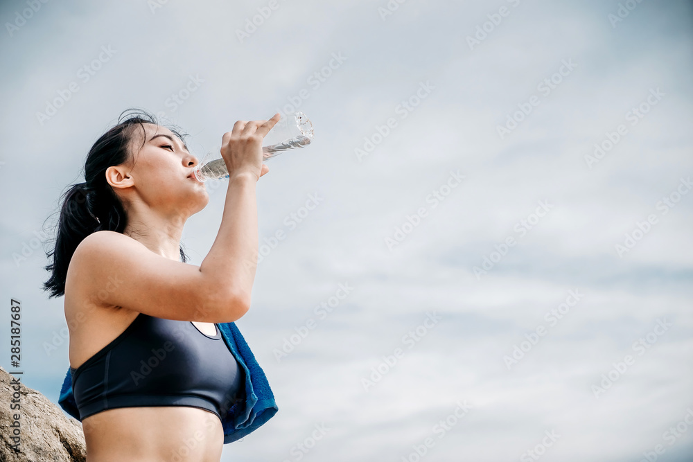 An beautiful Asian woman running and drinking some water during moring. Workout and sport outdoor concept. An beautiful Asian woman running and drinking some water during moring. Workout and sport outdoor concept.