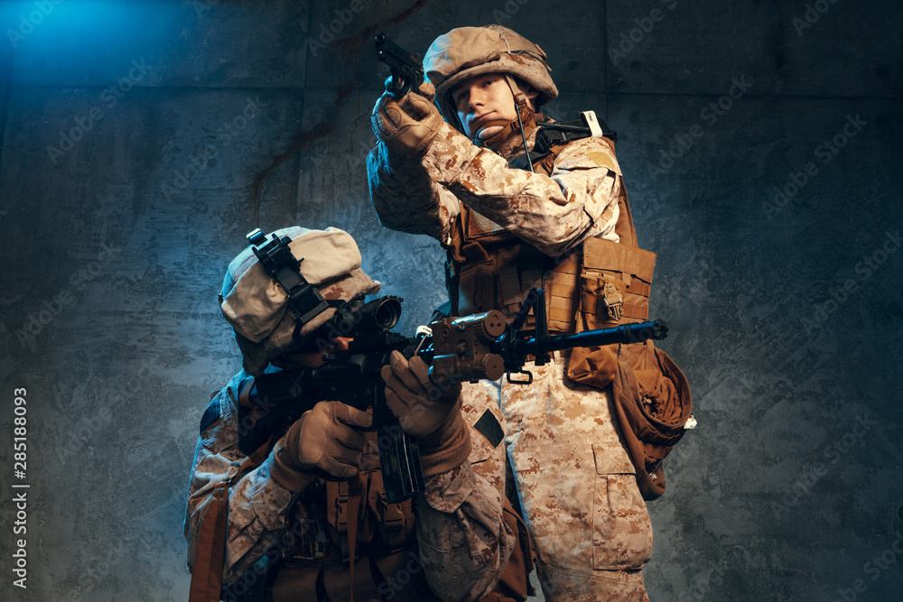 Two well equipped US army commandos armed with assault rifles. Studio shot
