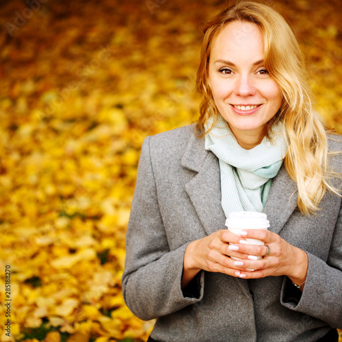 Obraz na płótnie Cheerful pretty woman drinking coffee in autumn park w salonie