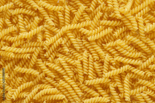 Dry uncooked girandole pasta as a background.