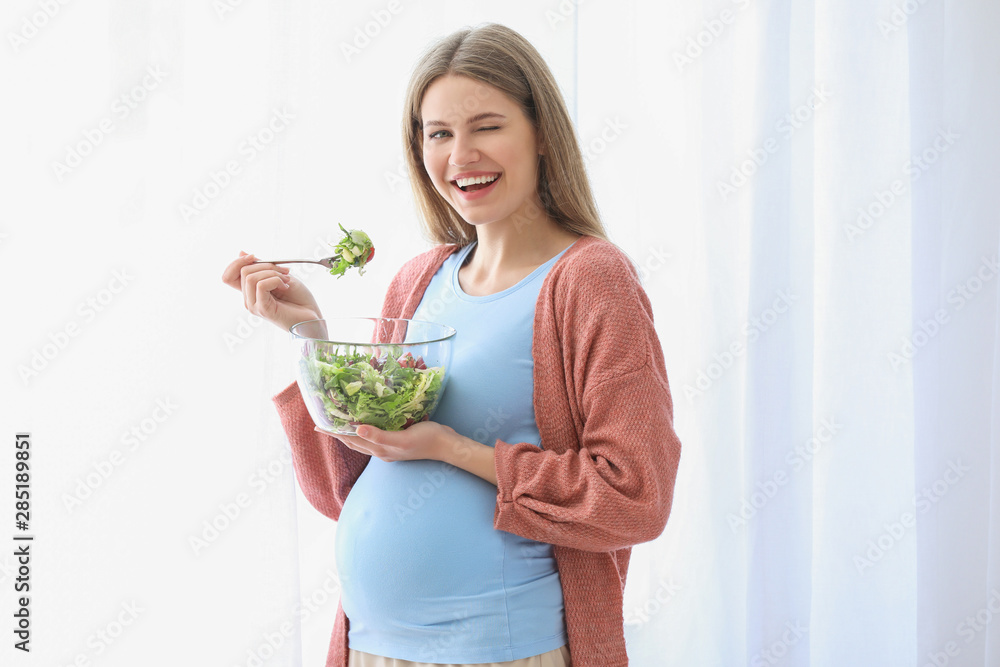 Beautiful pregnant woman eating salad at home Beautiful pregnant woman eating salad at home