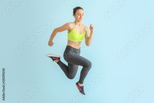 Running sporty woman on light color background