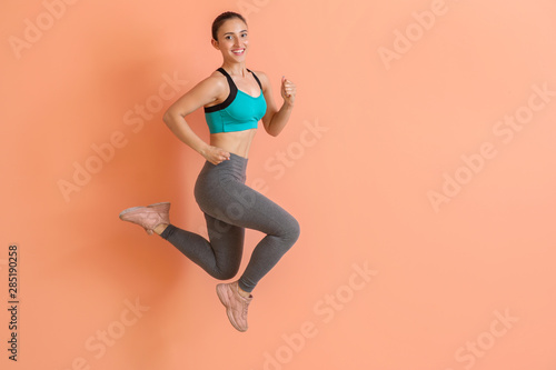 Fototapeta Naklejka Na Ścianę i Meble -  Running sporty woman on color background