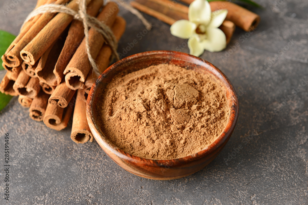 Aromatic cinnamon sticks and powder on grey background Aromatic cinnamon sticks and powder on grey background