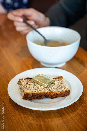 Fototapeta Naklejka Na Ścianę i Meble -  Close view of white plate with piece of bread and butter