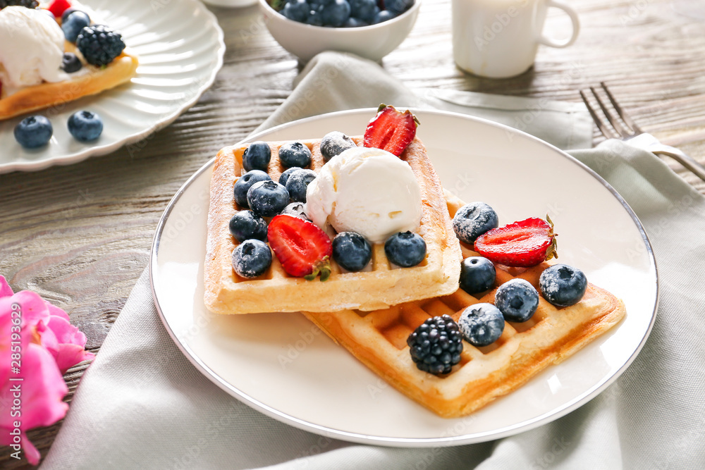 Plate with sweet waffles with ice cream and berries on table Plate with sweet waffles with ice cream and berries on table