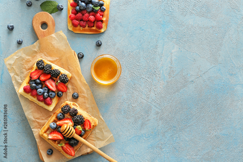 Tasty sweet waffles with honey on color background Tasty sweet waffles with honey on color background