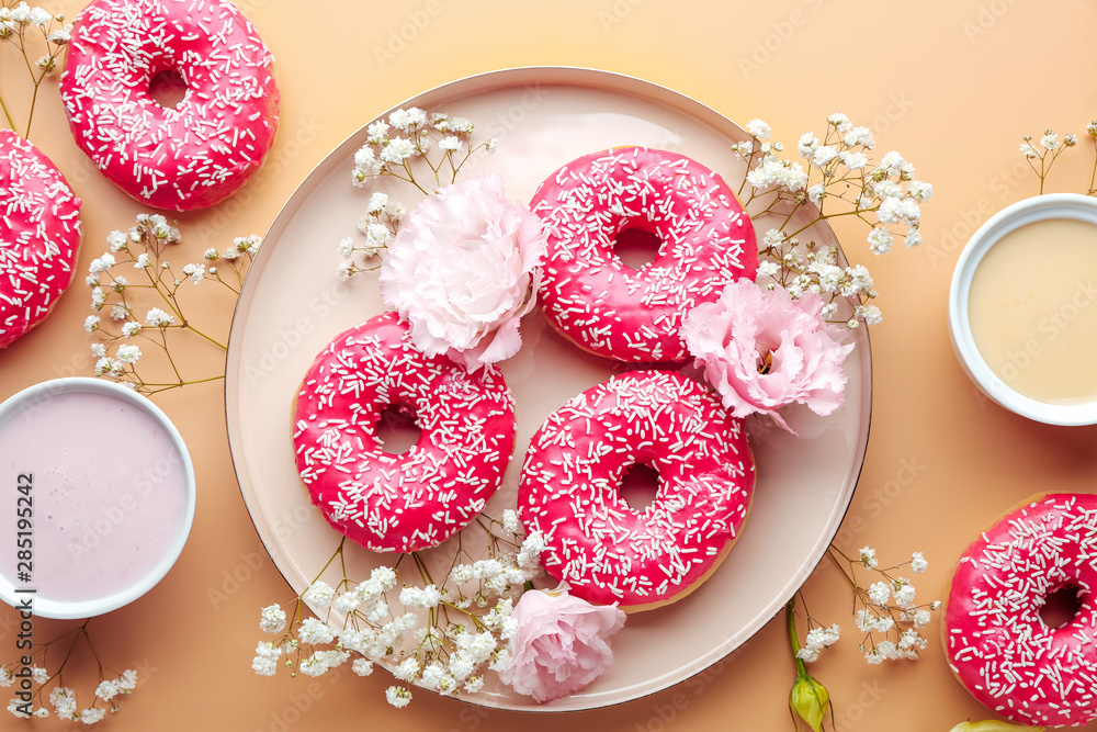 Composition with sweet tasty donuts and flowers on color background Composition with sweet tasty donuts and flowers on color background
