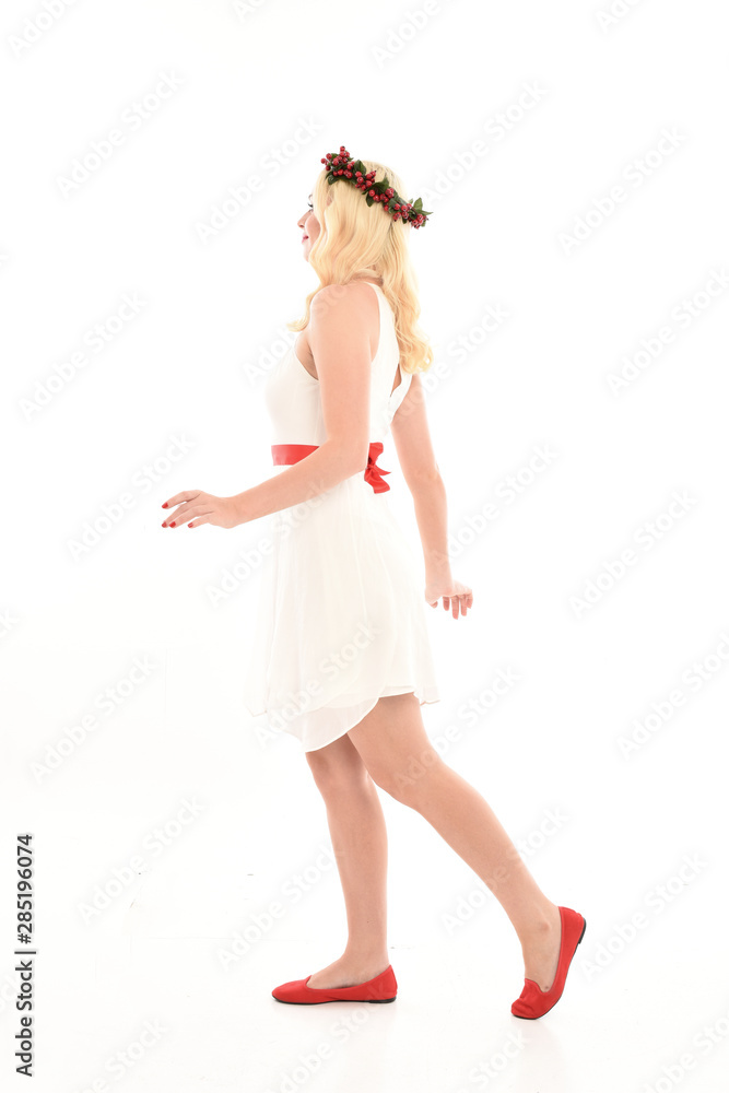 full length portrait of blonde girl wearing a white dress and flower crown. Standing pose, isolated against a white studio background. full length portrait of blonde girl wearing a white dress and flower crown. Standing pose, isolated against a white studio background.