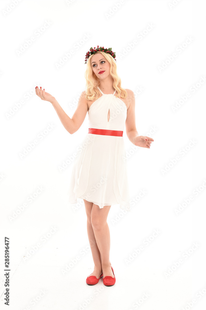 full length portrait of blonde girl wearing a white dress and flower crown. Standing pose, isolated against a white studio background. full length portrait of blonde girl wearing a white dress and flower crown. Standing pose, isolated against a white studio background.