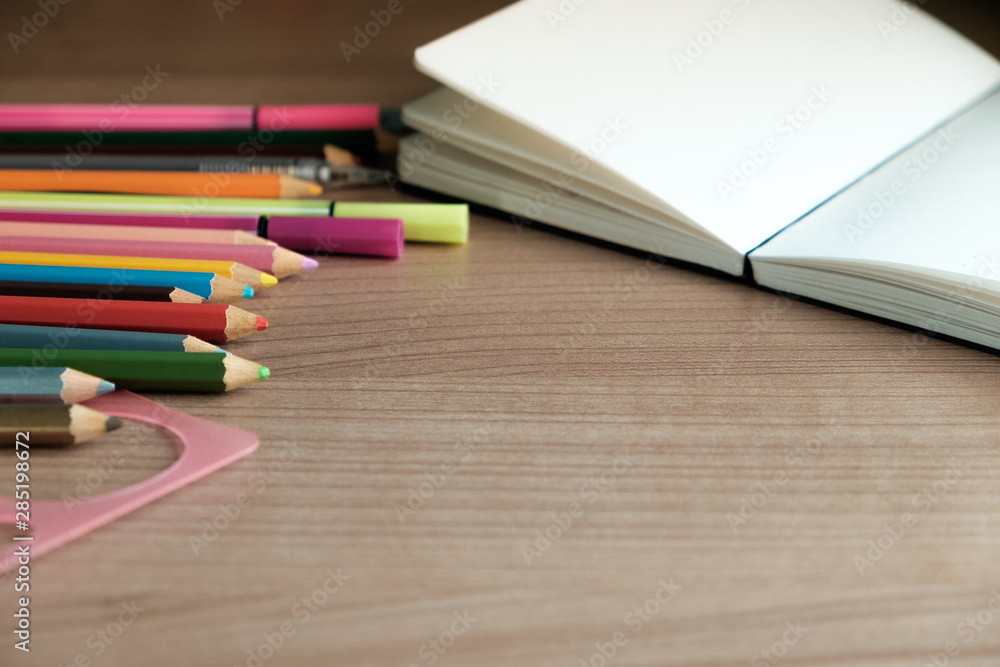 Obraz premium school supplies on wooden background,notebook,pencil ,coloured pencils,copy space.RAF