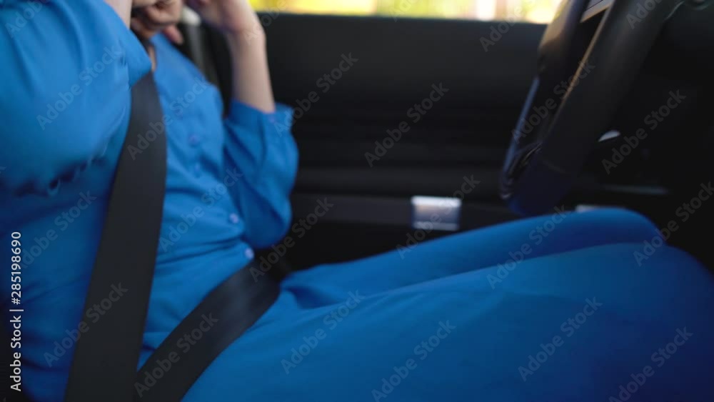 Woman fastening car safety seat belt while sitting inside of vehicle before driving Woman fastening car safety seat belt while sitting inside of vehicle before driving