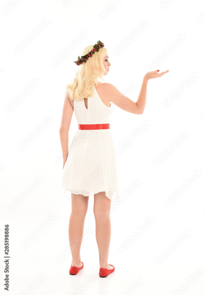 full length portrait of blonde girl wearing a white dress and flower crown. Standing pose, isolated against a white studio background. full length portrait of blonde girl wearing a white dress and flower crown. Standing pose, isolated against a white studio background.