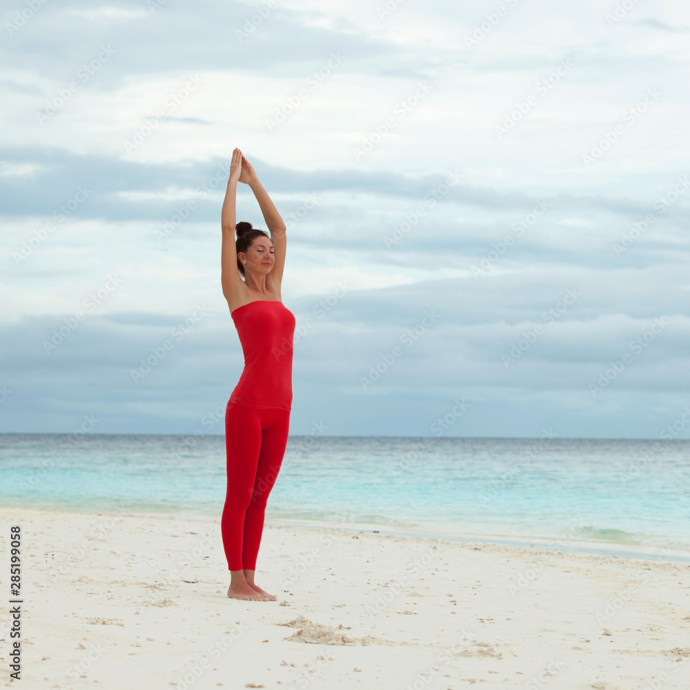 Yoga outdoor. Happy woman doing yoga exercises, meditate on the beach. Yoga meditation in nature. Concept of healthy lifestyle and relaxation. Pretty woman practicing yoga near the sea