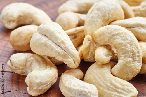 Close up picture of cashews on a wooden table, selective focus.