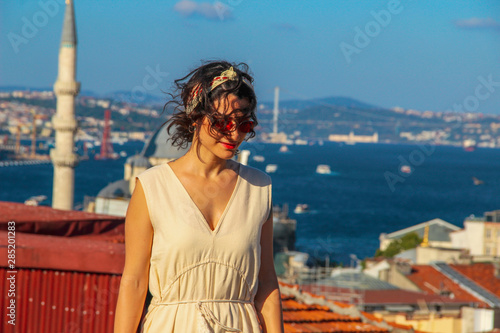 Eurasian woman standing at the roof with bosphorus background in Istanbul, Turkey