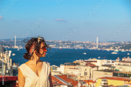 Fototapeta Naklejka Na Ścianę i Meble -  Eurasian woman standing at the roof with bosphorus background in Istanbul, Turkey