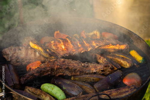 delicious Marinated grilled pork ribs with vegetables over the coals on a barbecue.