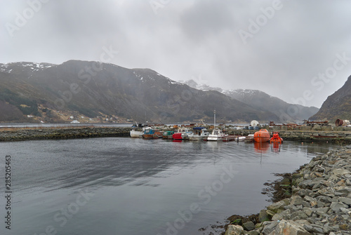 Small Boats, including a Ship's Lifeboat moored in a small stone man made harbour near Maloy Town, Vagsoy, Norway. photo