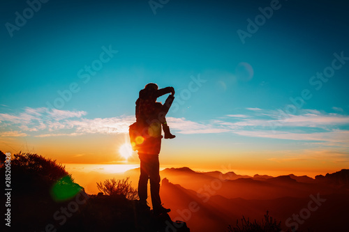 happy father and daughter travel in mountains at sunset