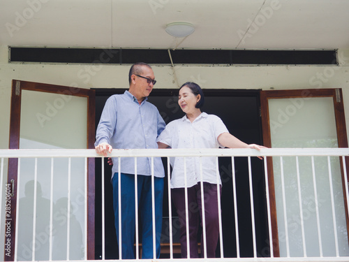 elder couple standing on the balcony