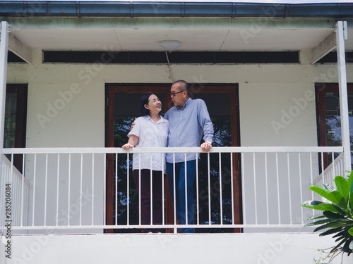 elder couple standing on the balcony © potsawat