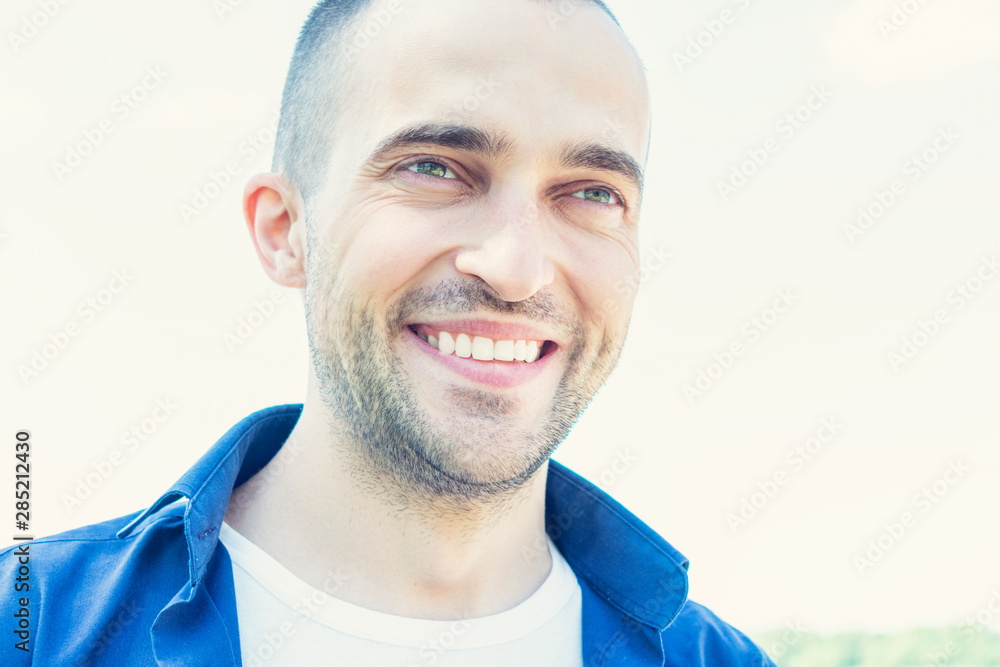 Happy young man in Park in summer, man smiling, look aside, portrait, closeup, toned Happy young man in Park in summer, man smiling, look aside, portrait, closeup, toned