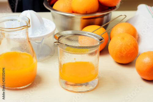 Young woman making juice with fresh oranges with manual juicer. Healthy lifestyle.