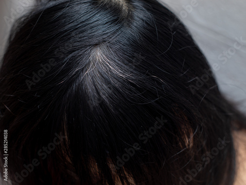 Young woman shows her white hair roots © S@photo