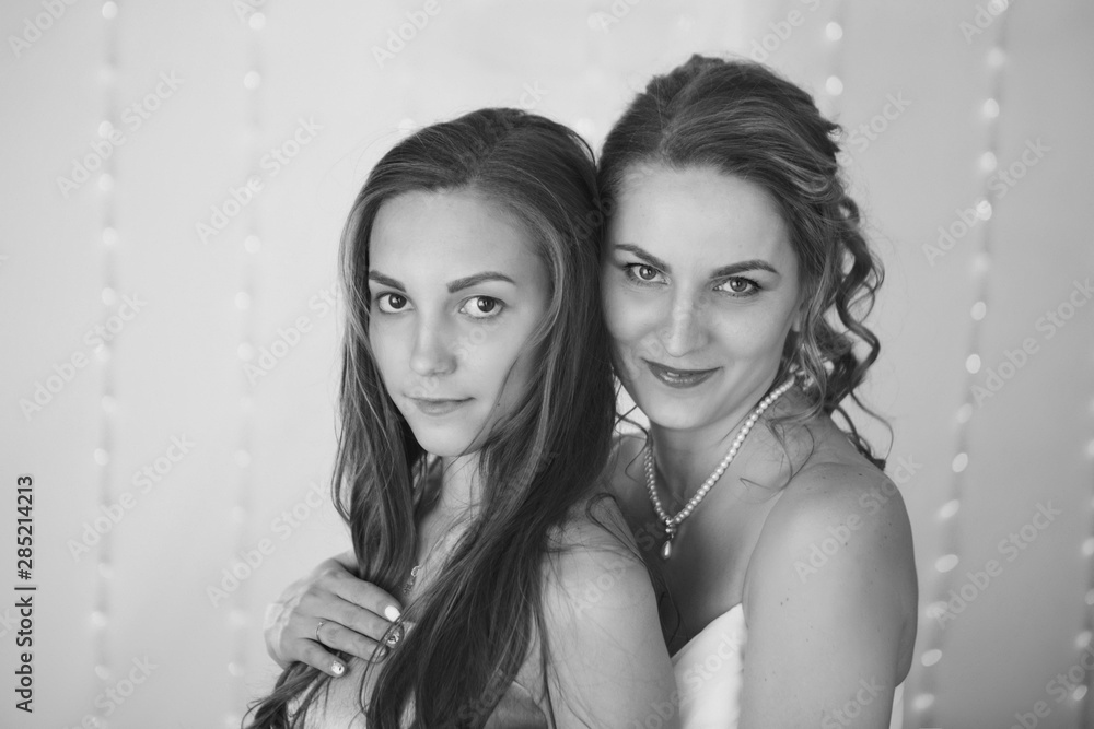 Fototapeta premium advertising of fashion for woman: dress, shoes. two happy girls smiling. Portrait of women hugging. The concept of relationships in the family, friends, sisters, couple in love. isolated on white back