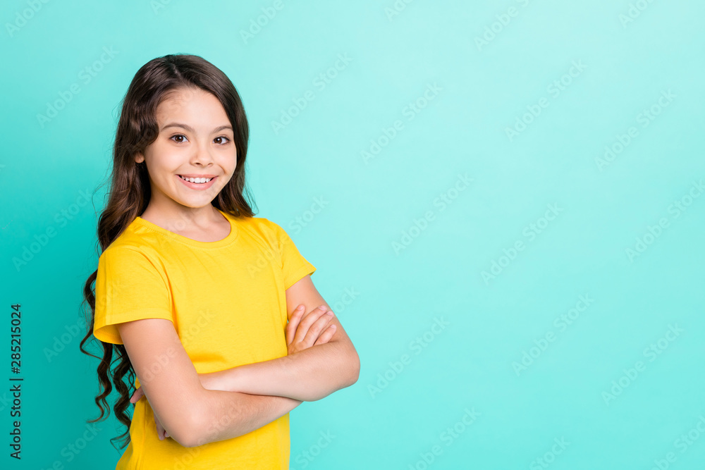 Photo of excited charming cute turned girl with her hands folded standing while isolated with teal background Photo of excited charming cute turned girl with her hands folded standing while isolated with teal background