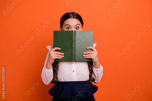 Portrait cute sweet kid hold hand printed book close face new information look news dressed white blouse shirt modern skirt dress isolated orange vibrant background