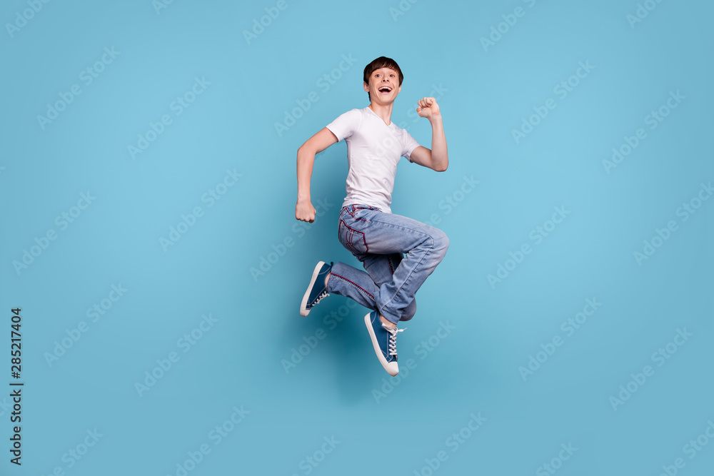 Full length body size photo of boy having made up his mind to run away from this planet while isolated with blue background Full length body size photo of boy having made up his mind to run away from this planet while isolated with blue background