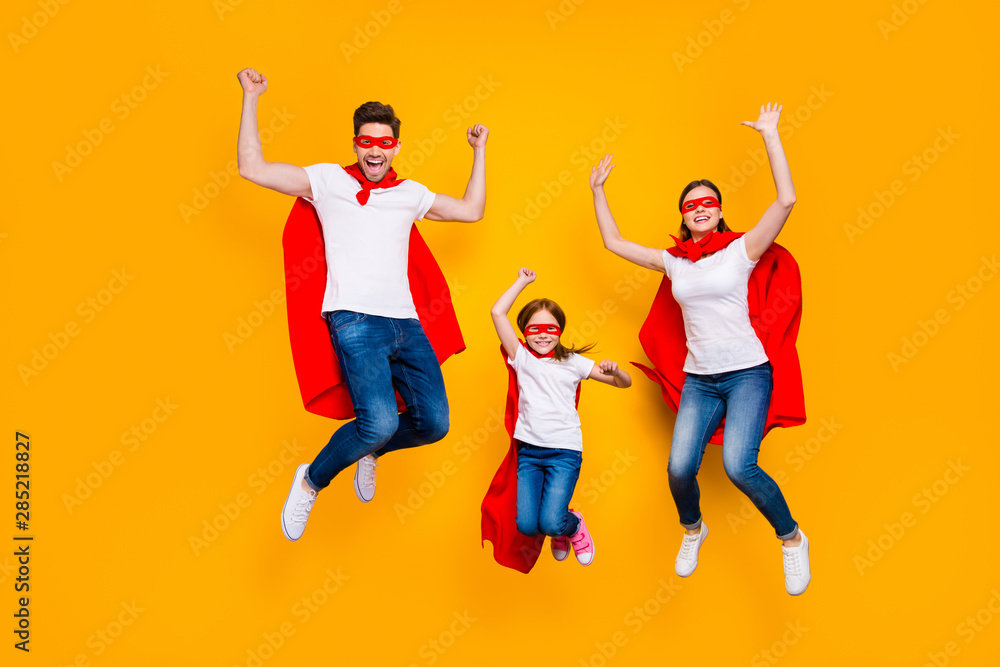 Crazy daddy mommy and foxy daughter jumping high wear cartoon superhero capes isolated yellow background