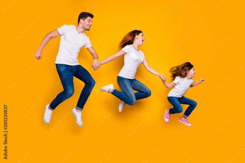 Full length body size view of three nice attractive sporty cheerful funny funky person active activity motion holding hands sale discount hurry rush isolated over bright vivid shine yellow background