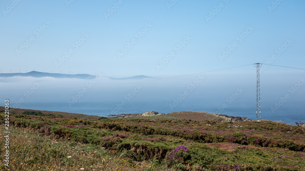 Wind farms on the Cabo Vilan Peninsula, La Coruña Province, Spain. In this place there is constantly fog, which continuously changes its shape.