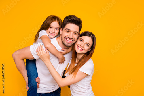 Portrait of three nice attractive lovely cheerful cheery kind tender sweet person having fun weekend holiday mommy daddy day isolated over bright vivid shine yellow background
