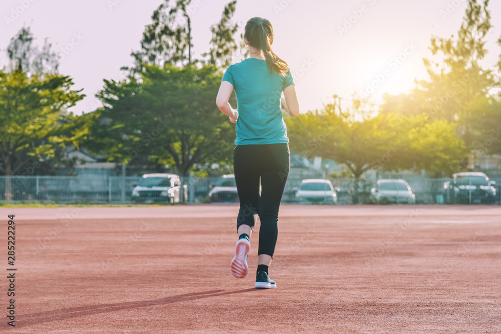Runner Women jogging or running in evening at sunlight Runner Women jogging or running in evening at sunlight