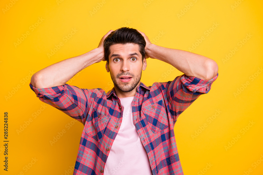 Photo of scared stunned man in stupor having no idea what to do with what he sees while isolated with yellow background Photo of scared stunned man in stupor having no idea what to do with what he sees while isolated with yellow background