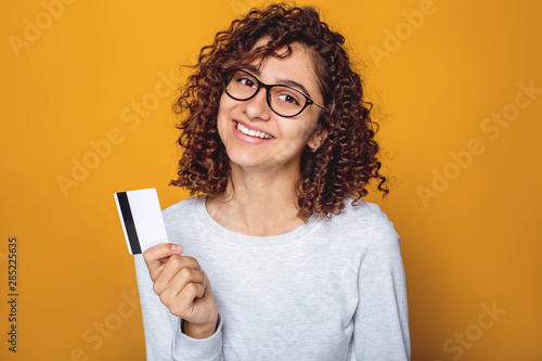 Portrait of a smiling Indian young woman holding a credit card in her hand Poster Mural XXL